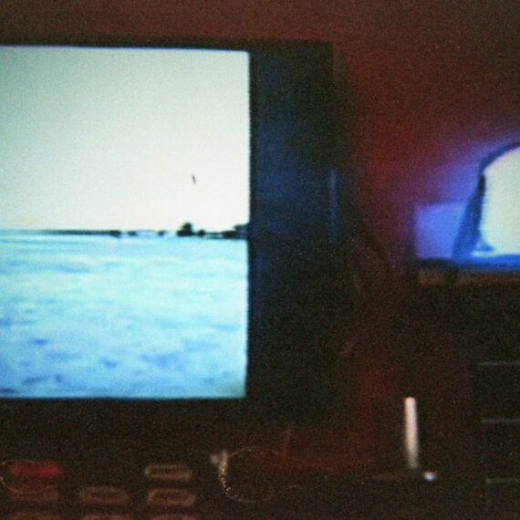 Photo of a television screen showing a body of water. Next to the screen is a glowing blue orb resting on an elevated surface.